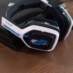 Astro Gaming A20 Gen 2 wireless headset showing flip-to-mute mic & ear cup controls for PS5